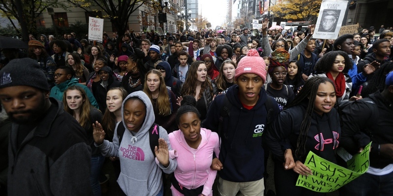 Protesters march in downtown Seattle, Tuesday, Nov. 25, 2014, to demonstrate against a grand jury's decision not to indict a white Ferguson, Missouri, police officer who killed a black 18-year-old. The peaceful march was a mix of students who walked out of schools and a coalition of clergy members. (AP Photo/Ted S. Warren)